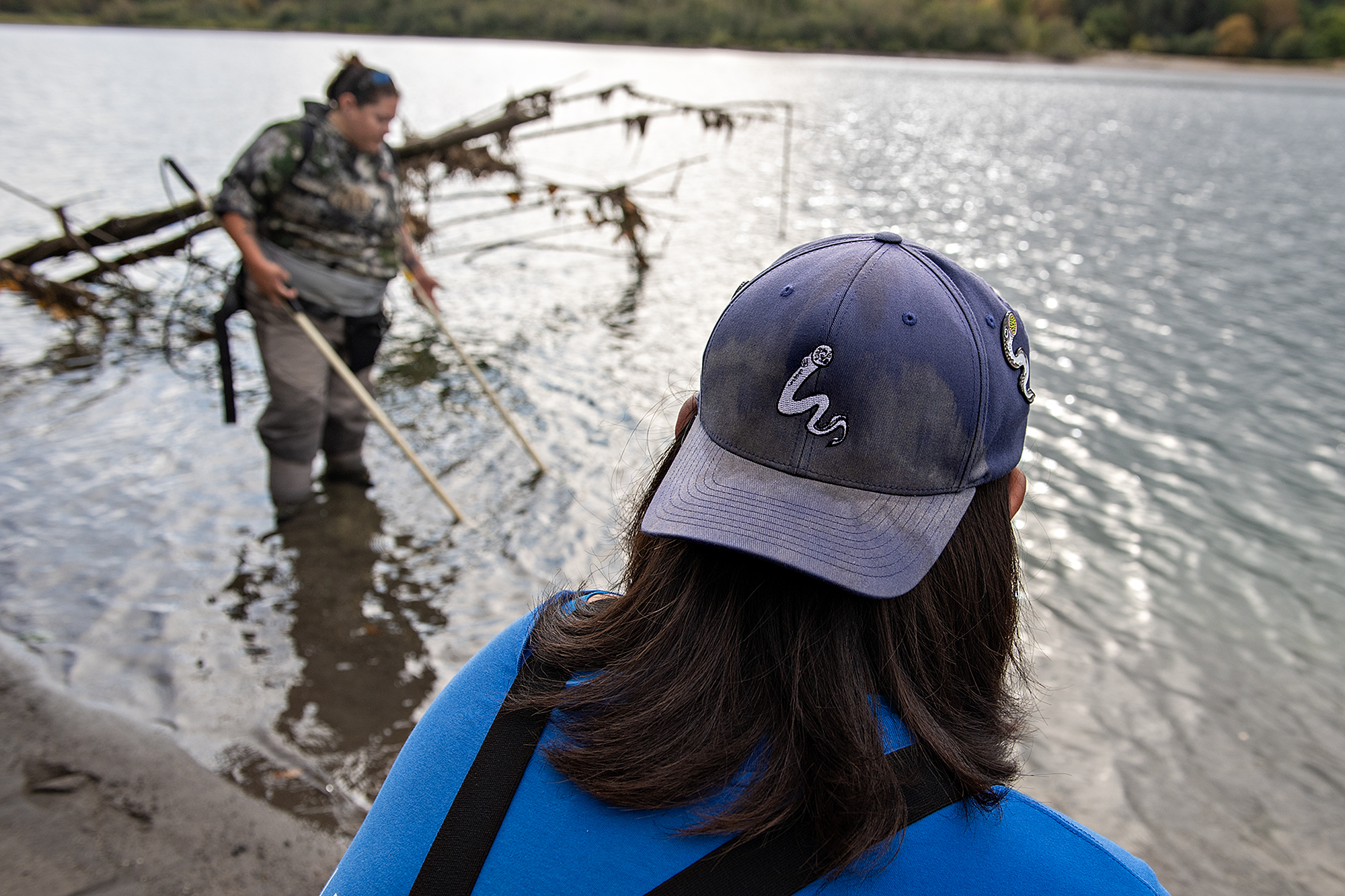 Dave’y Lumley of Yakama Nation Fisheries, left, surveys for new lamprey sites on the Lewis River with colleague Noah Sampson, who has a lamprey on his hat, in Woodland on Wednesday morning, Sept. 25, 2024.