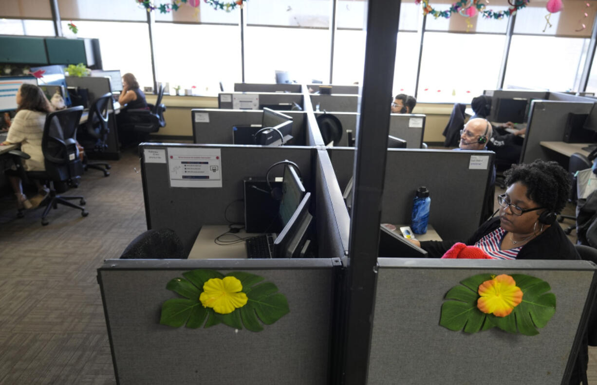 Customer Experience Representative Cassia Jones-Woodard, right, and other representatives take calls at an Alorica center, Monday, Aug. 19, 2024, in San Antonio.