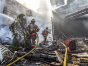 In this photo provided by Portland Fire &amp; Rescue, firefighters use handlines to extinguish the fire adjacent to the primary structure involved after a small plane crashed Saturday, Aug. 31, 2024, in Fairview, Ore.