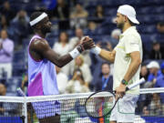 Grigor Dimitrov, of Bulgaria, right, shakes hands with Frances Tiafoe, of the United States, after he was forced to retire due to an apparent injury during the quarterfinals of the U.S. Open tennis championships, Tuesday, Sept. 3, 2024, in New York.