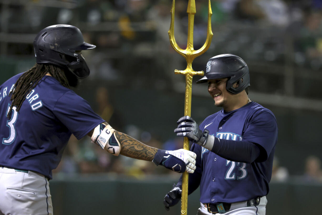 Seattle Mariners' Luis Urías (23) celebrates with J.P. Crawford (3) after hitting a home run against the Oakland Athletics during the seventh inning of a baseball game in Oakland, Calif., Wednesday, Sept. 4, 2024.