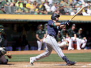 Seattle Mariners catcher Cal Raleigh, right, watches his two-run home run in front of Oakland Athletics catcher Kyle McCann, left, during the first inning of a baseball game in Oakland, Calif., Thursday, Sept. 5, 2024.