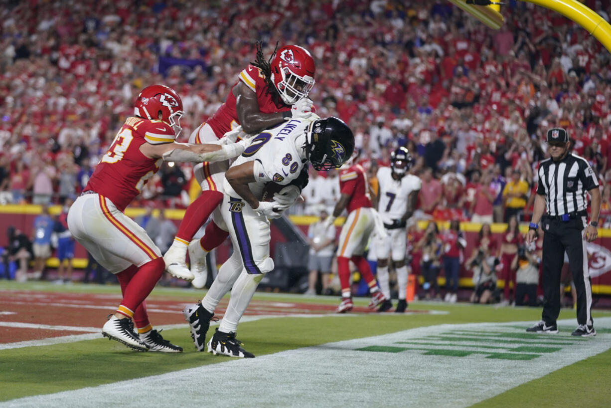 Baltimore Ravens tight end Isaiah Likely (80) catches a pass with his toe out of bounds as Kansas City Chiefs linebacker Nick Bolton and linebacker Drue Tranquill, left, defend as time time expires in the second half of an NFL football game Thursday, Sept. 5, 2024, in Kansas City, Mo.