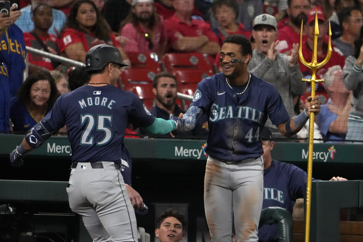 Seattle Mariners' Dylan Moore (25) is congratulated by teammate Julio Rodriguez (44) after hitting a two-run home run during the sixth inning of a baseball game against the St. Louis Cardinals Friday, Sept. 6, 2024, in St. Louis.