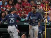 Seattle Mariners' Dylan Moore (25) is congratulated by teammate Julio Rodriguez (44) after hitting a two-run home run during the sixth inning of a baseball game against the St. Louis Cardinals Friday, Sept. 6, 2024, in St. Louis.