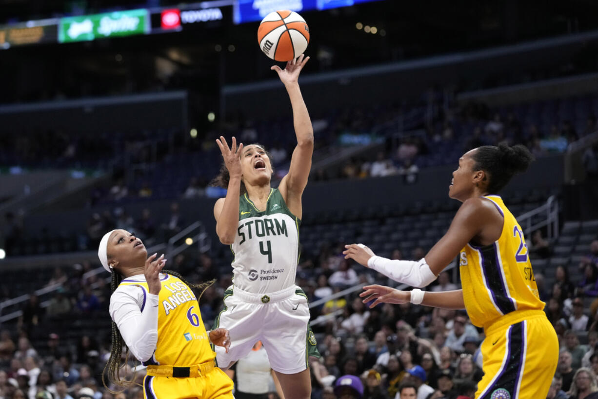 Seattle Storm guard Skylar Diggins-Smith, center, shoots as Los Angeles Sparks' Odyssey Sims, left, and Azura Stevens defend during the first half of a WNBA basketball game, Wednesday, Sept. 11, 2024, in Los Angeles. (AP Photo/Mark J.