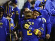 Seattle Mariners' Julio Rodriguez, right, gets a big hug from Justin Turner following his three-run homer in the eighth inning of a baseball game against the Texas Rangers, Friday, Sept.