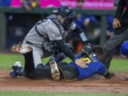 New York Yankees catcher Austin Wells tags out Seattle Mariners' Victor Robles attempting to steal home plate during the first inning of a baseball game, Tuesday, Sept. 17, 2024, in Seattle.