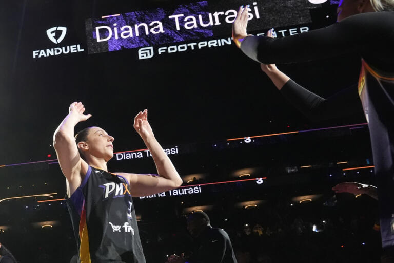 Phoenix Mercury guard Diana Taurasi, left, is greeted by Mercury guard Sophie Cunningham during player introductions prior to a WNBA basketball game against the Seattle Storm, Thursday, Sept. 19, 2024, in Phoenix. (AP Photo/Ross D.