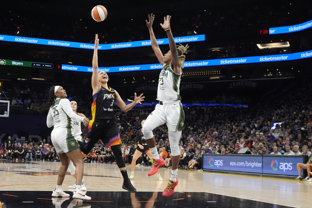 Phoenix Mercury guard Diana Taurasi (3) drives between Seattle Storm guard Victoria Vivians (35) and Storm guard Jordan Horston, right, during the first half of a WNBA basketball game Thursday, Sept. 19, 2024, in Phoenix. (AP Photo/Ross D.