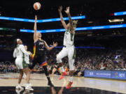 Phoenix Mercury guard Diana Taurasi (3) drives between Seattle Storm guard Victoria Vivians (35) and Storm guard Jordan Horston, right, during the first half of a WNBA basketball game Thursday, Sept. 19, 2024, in Phoenix. (AP Photo/Ross D.