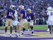 Washington wide receiver Denzel Boston (12) celebrates his touchdown with tight end Decker DeGraaf, front right, during the first half of an NCAA college football game against Northwestern, Saturday, Sept. 21, 2024, in Seattle.