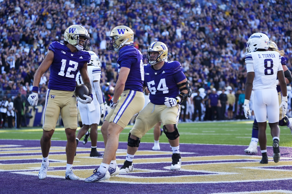 Washington wide receiver Denzel Boston (12) celebrates his touchdown with tight end Decker DeGraaf, front right, during the first half of an NCAA college football game against Northwestern, Saturday, Sept. 21, 2024, in Seattle.