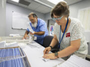 FILE - Dawn Stephens, right, and Duane Taylor prepare ballots to be mailed at the Mecklenburg County Board of Elections in Charlotte, N.C., Sept. 5, 2024.