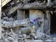 A boy checks the damage to a building hit in an Israeli airstrike in the southern village of Akbieh, Lebanon, Tuesday, Sept. 24, 2024.