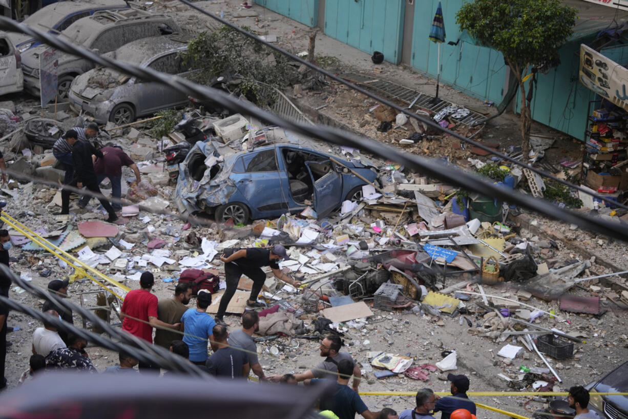 Residents check the site of an Israeli airstrike in Beirut's southern suburbs, Tuesday, Sept. 24, 2024.