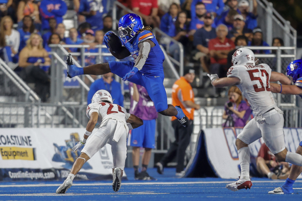 Boise State running back Ashton Jeanty (2) hurdles Washington State defensive back Ethan O'Connor (24) on a run in the second quarter of an NCAA college football game, Saturday, Sept. 28, 2024, in Boise, Idaho.