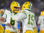 Oregon quarterback Dillon Gabriel, left, celebrates after throwing a touchdown pass to wide receiver Tez Johnson (15) during the first half of an NCAA college football game against UCLA, Saturday, Sept. 28, 2024, in Pasadena, Calif.