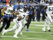 Seattle Seahawks quarterback Geno Smith (7) rushes against the Detroit Lions in the first half of an NFL football game in Detroit, Monday, Sept. 30, 2024.