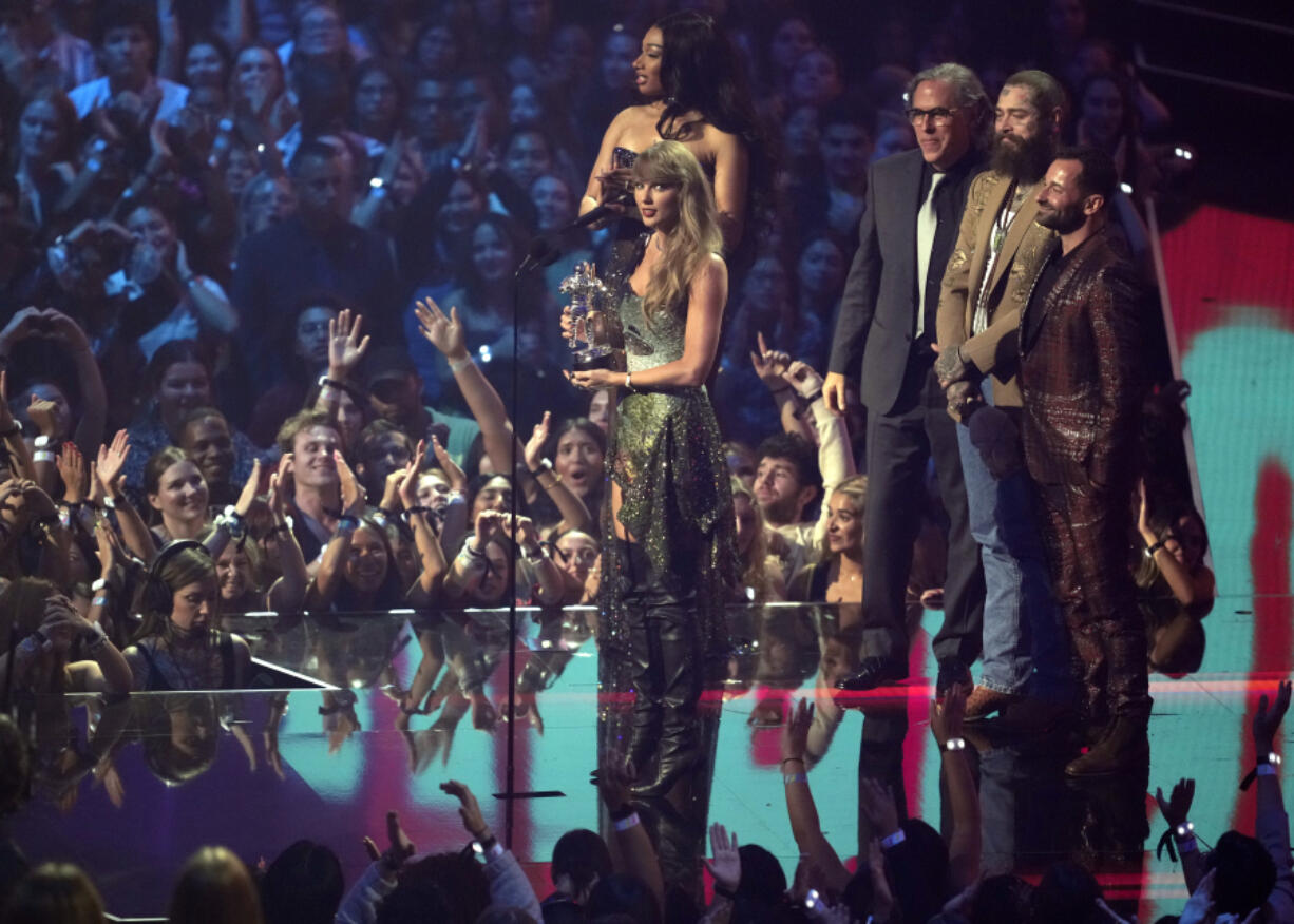 Taylor Swift, center, and Post Malone, third from back left, accept the video of the year award for &quot;Fortnight&quot; during the MTV Video Music Awards on Wednesday, Sept. 11, 2024, at UBS Arena in Elmont, N.Y. Host Megan Thee Stallion, from far left back, Rodrigo Prieto, and Ethan Tobman, far right, look on.