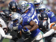 Seattle Seahawks running back Kenneth Walker III (9) is tackled by Denver Broncos players during the first half Sunday in Seattle.