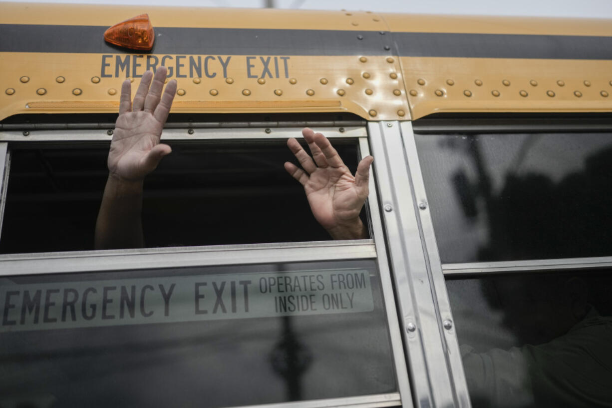 Nicaraguan citizens wave from a bus after being released from a Nicaraguan jail and landing at the airport in Guatemala City, Thursday, Sept. 5, 2024.