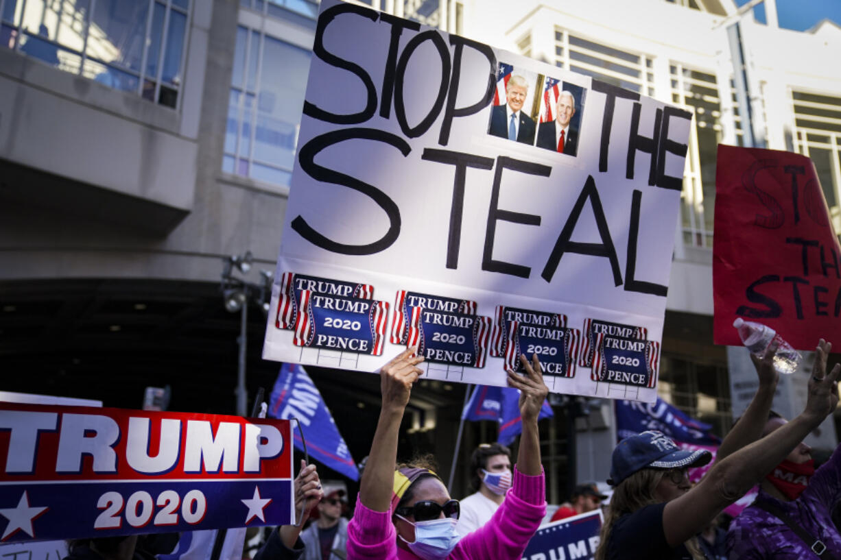 FILE - President Donald Trump supporters gather with some signs claiming a stolen election outside the Philadelphia Convention Center as they await general election tabulation results, Nov. 6, 2020, in Philadelphia.