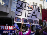 FILE - President Donald Trump supporters gather with some signs claiming a stolen election outside the Philadelphia Convention Center as they await general election tabulation results, Nov. 6, 2020, in Philadelphia.