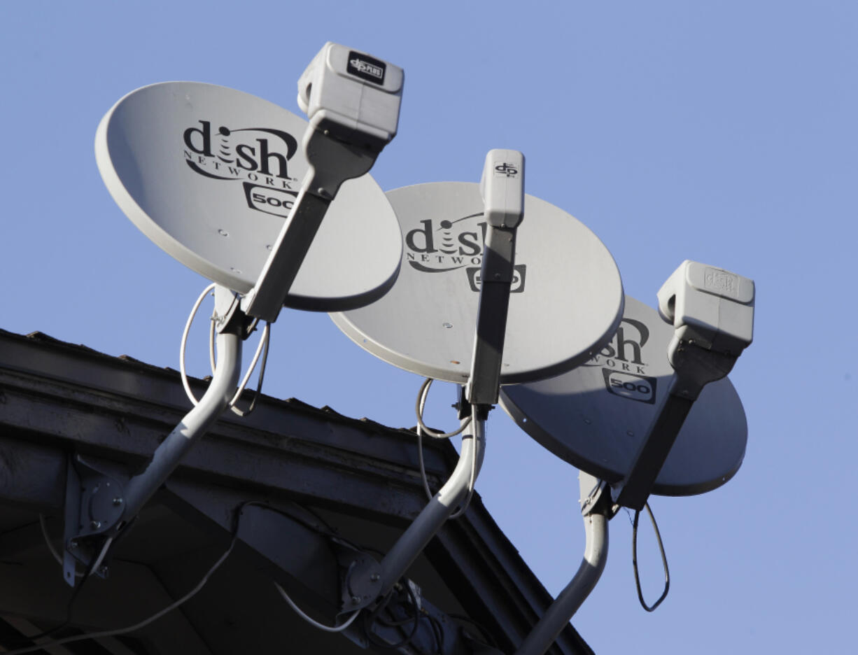 FILE - In this Feb. 23, 2011, file photo, Dish Network satellite dishes are shown at an apartment complex in Palo Alto, Calif.