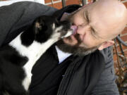 Ben Cochell, a volunteer for PAWsitive Recovery, lets his foster dog Dexter lick his face March 26 at his home in Denver.