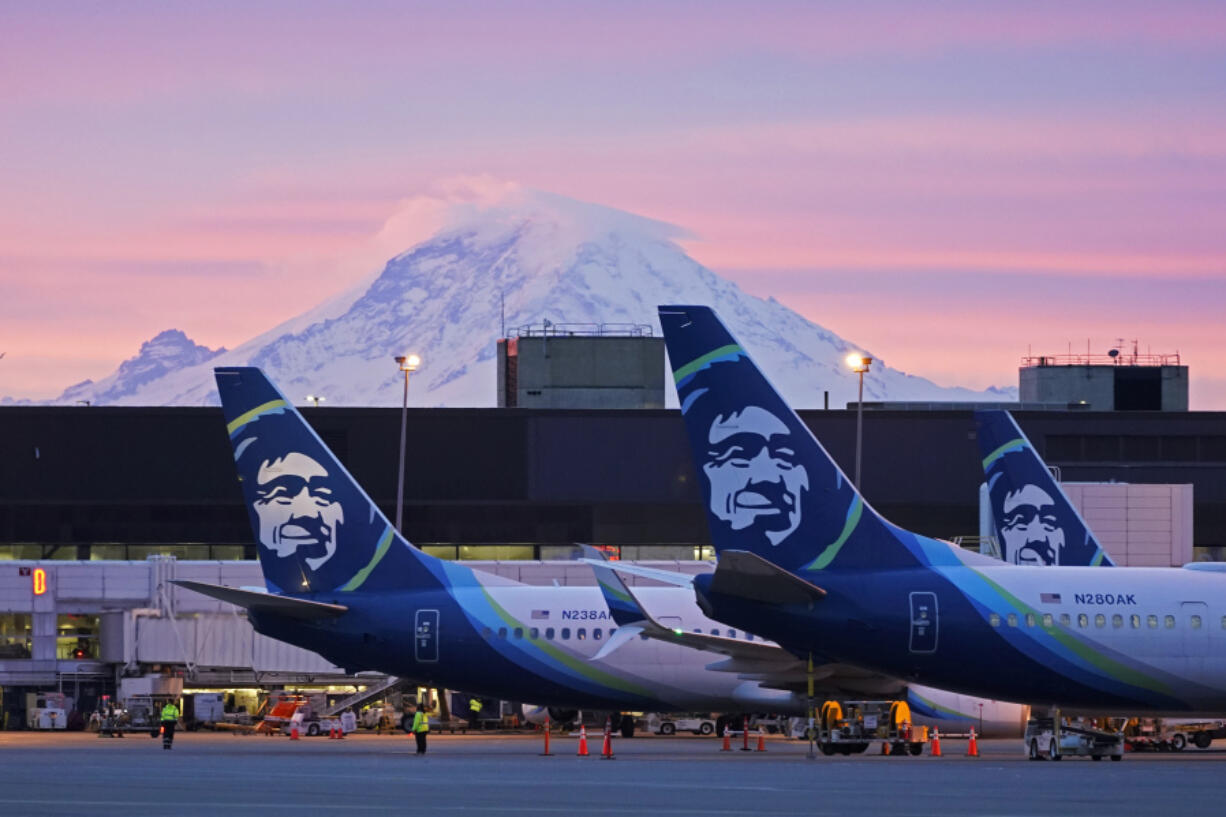 FILE - Alaska Airlines planes are shown parked at gates with Mount Rainier in the background on March 1, 2021, at Seattle-Tacoma International Airport in Seattle. (AP Photo/Ted S.