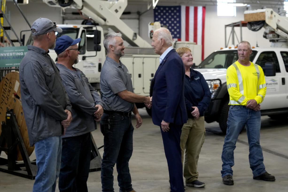 President Joe Biden, third from right, greets workers from Dairyland Power Cooperative and Vernon Electric Cooperative during a visit to Vernon Electric in Westby, Wis., Thursday, Sept. 5, 2024. Biden is in Wisconsin to promote his Investing in America agenda.