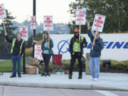 Boeing Machinists Union members from left, Brent Roberts, Ha Nguyen, Myles Simms and Rich Russell, wave to passing traffic while on the picket line at the Renton assembly plant, Friday, Sept. 13, 2024, in Renton, Wash.