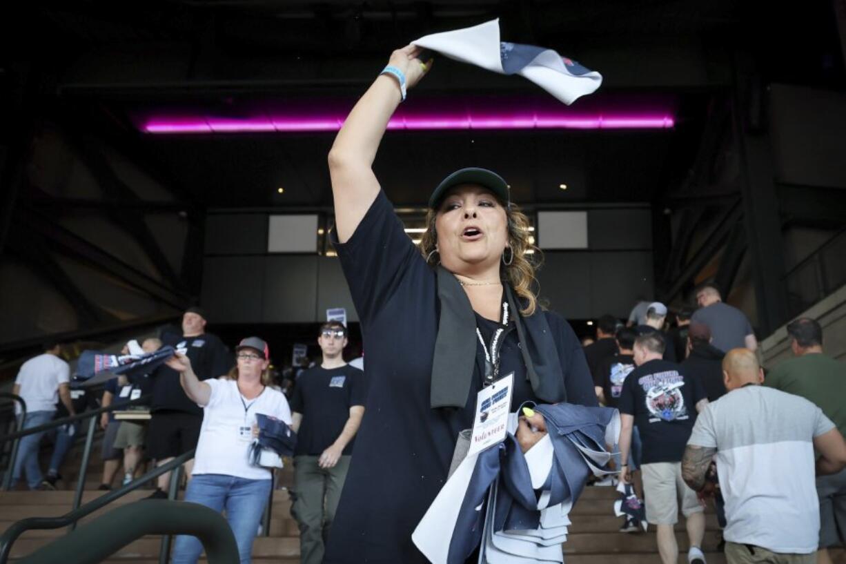 Cristina Green waves a towel to machinists and fellow union members for a &quot;stop work meeting&quot; and strike sanction at T-Mobile Park in Seattle, July 17, 2024.