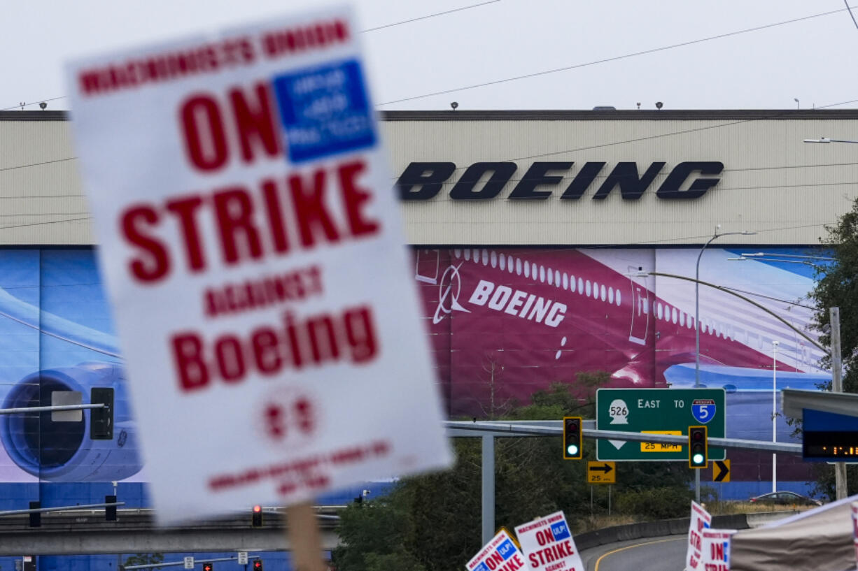 Boeing workers wave picket signs as they strike after union members voted to reject a contract offer, Sunday, Sept. 15, 2024, near the company&#039;s factory in Everett, Wash.