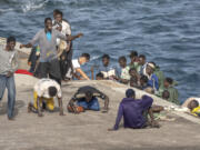 CORRECTS TO DELETE THE EXTRANEOUS WORD OF &quot;UNAUTHORIZED&quot; - FILE - Migrants react as they arrive at the port in La Restinga on the Canary island of El Hierro, Spain, on, Aug. 19, 2024.