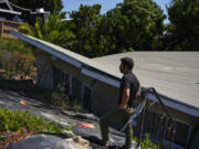 A reporter stands near a home that collapsed due to ongoing landslides in Rancho Palos Verdes, Calif., Tuesday, Sept. 3, 2024. (AP Photo/Jae C.