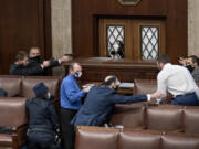 FILE - Security forces draw their guns as rioters loyal to President Donald Trump try to break into the House of Representatives chamber to disrupt the Electoral College process, at the Capitol in Washington,  Jan. 6, 2021.  (AP Photo/J.