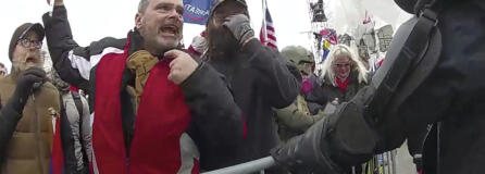 FILE- This still frame from Metropolitan Police Department body worn camera video shows Thomas Webster, in red jacket, at a barricade line at on the west front of the U.S. Capitol on Jan. 6, 2021, in Washington. Jurors deliberated for less than three hours before convicting the 20-year NYPD veteran, Thomas Webster, of all six counts in his indictment. Webster was sentenced to 10 years in prison.