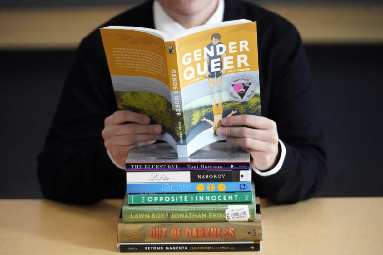 Amanda Darrow, director of youth, family and education programs at the Utah Pride Center, poses with books that have been the subject of complaints from parents, including &ldquo;Gender Queer&rdquo; by Meir Kobabe, on Dec. 16, 2021, in Salt Lake City.