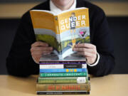 Amanda Darrow, director of youth, family and education programs at the Utah Pride Center, poses with books that have been the subject of complaints from parents, including &ldquo;Gender Queer&rdquo; by Meir Kobabe, on Dec. 16, 2021, in Salt Lake City.