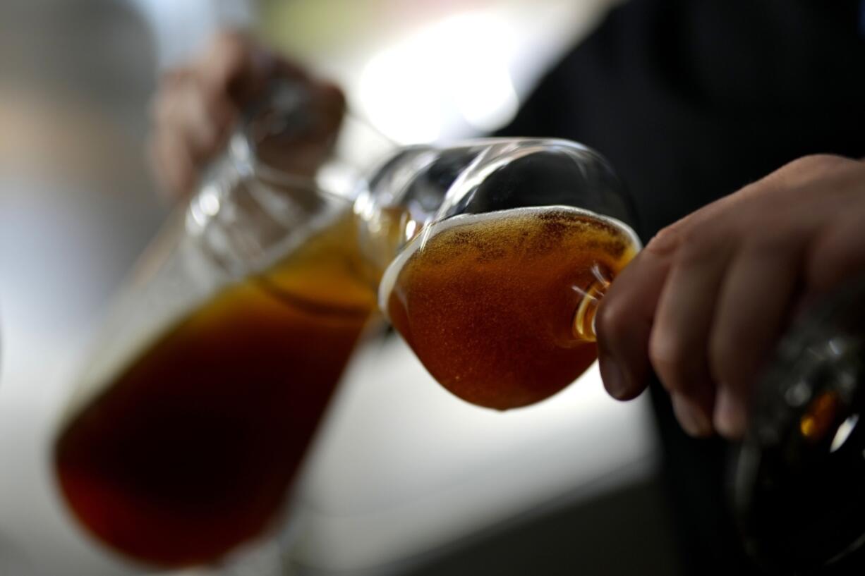 An employee of the Technical University of Munich fills beer in the brewery in Freising, Germany, Thursday, Sept. 19, 2024.