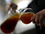 An employee of the Technical University of Munich fills beer in the brewery in Freising, Germany, Thursday, Sept. 19, 2024.