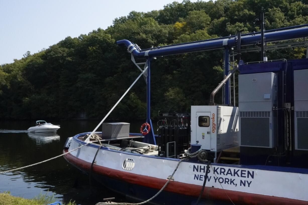 A boat, left, passes by the NH3 Kraken, a tugboat powered by ammonia, Friday, Sept. 13, 2024, in Kingston, N.Y.