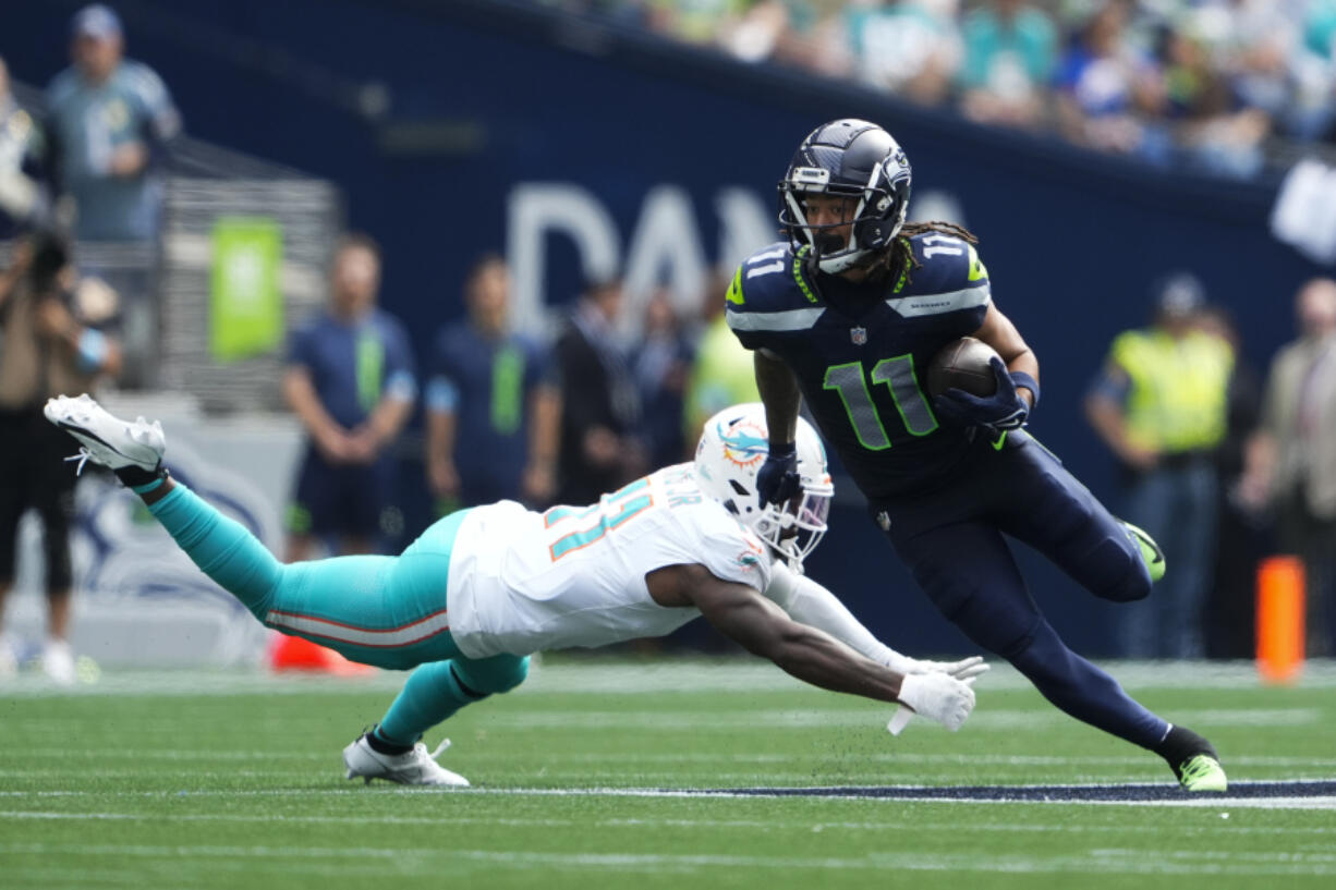 Seattle Seahawks wide receiver Jaxon Smith-Njigba (11) is tackled by Miami Dolphins cornerback Kader Kohou (4) during the first half of an NFL football game Sunday, Sept. 22, 2024, in Seattle.