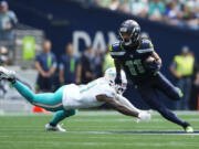 Seattle Seahawks wide receiver Jaxon Smith-Njigba (11) is tackled by Miami Dolphins cornerback Kader Kohou (4) during the first half of an NFL football game Sunday, Sept. 22, 2024, in Seattle.