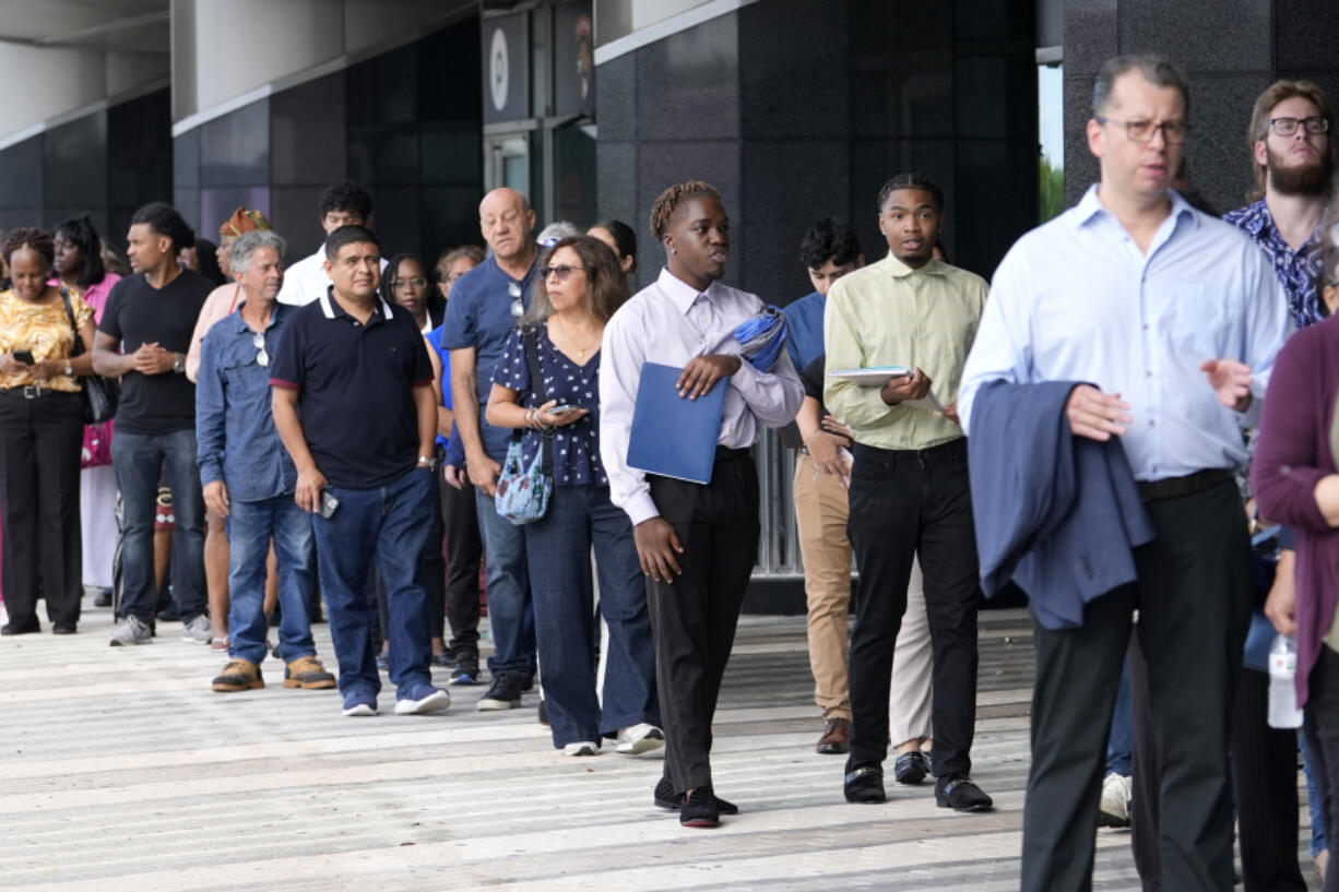 People wait in line to attend a job fair, Thursday, Aug. 29, 2024, in Sunrise, Fla.