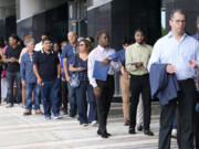 People wait in line to attend a job fair, Thursday, Aug. 29, 2024, in Sunrise, Fla.