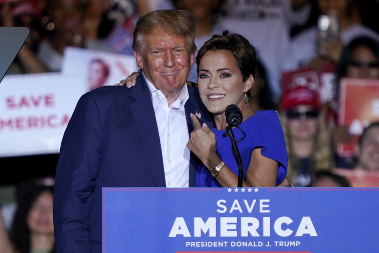 FILE - Arizona Republican gubernatorial candidate Kari Lake, right, speaks as former President Donald Trump listens during a rally, Oct. 9, 2022, in Mesa, Ariz.