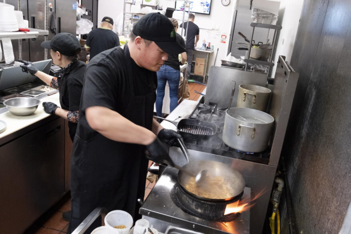 FILE - Tito Thepkaysone cooks up some pad Thai at &quot;Love &amp; Thai&quot; restaurant in Fresno, Calif., Wednesday, Dec. 20, 2023. The Thai restaurant was wrongfully accused of abusing a dog to turn it into meat, a false claim rooted in a racist stereotype.